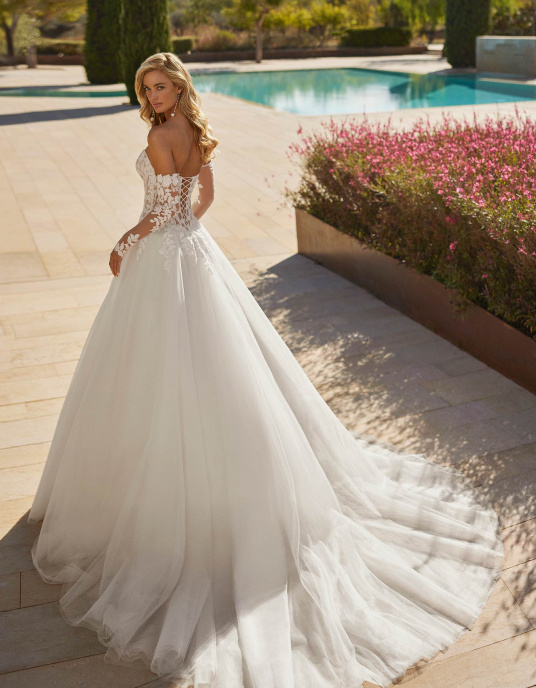 Robes de mariées  ADRIANA ALIER SIMONA est une Robe de mariée longue volumineuse en tulle avec bustier en dentelle, perles, encolure bustier, manches amovibles et dos corset. 