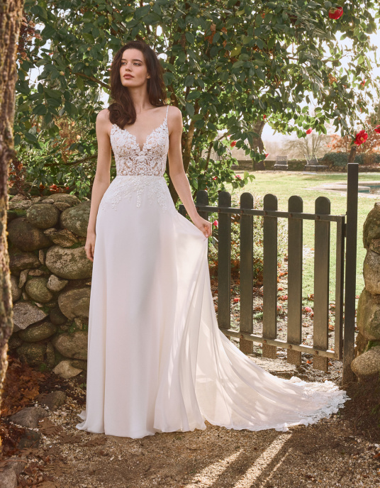 Robes de mariées  ALBERTO PALATCHI Cheryl La mousseline de soie raffinée offre un jeu de transparences sur le corsage et la traîne en tulle brodé et fleurs. La réinterprétation du décolleté en cœur et le dos ouvert apportent une touche de modernité. Il est réalisé en broderie de fils fins  