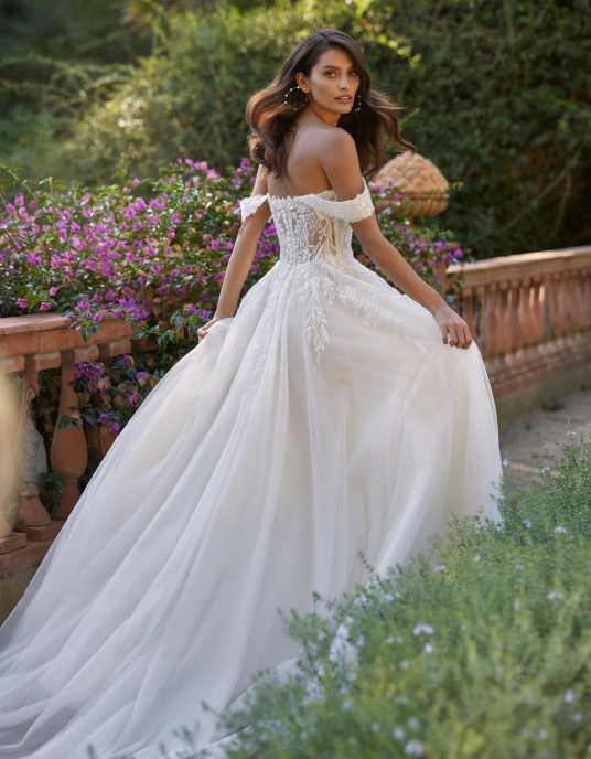 Robes de mariées   Delphe Robe de mariée romantique de style fourreau confectionnée en tulle, dentelle et perles. Modèle doté d'un décolleté plongeant, de bretelles amovibles et d'une jupe fendue sur le côté. 