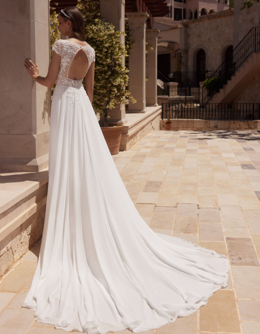 Robes de mariées  Bianco Evento "Agate" est une robe de mariée trapèze, fabriquée avec de la mousseline et de la dentelle de haute qualité. Cette robe de mariée moderne est dotée de manches à godets, d'un décolleté en V sensuel sur le devant et d'un dos ouvert. 