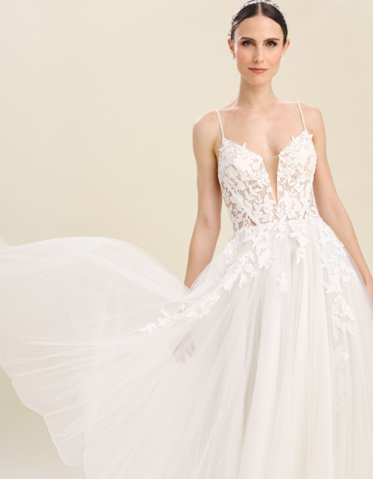 Robes de mariées  Bianco Evento Kosmos Robe de mariée princesse au style romantique, réalisée en dentelle de coton et en tulle doux. Elle présente un décolleté en V, un dos droit, une coupe sans manches ainsi qu’une longue traîne raffinée. Son corsage est orné d’une délicate dentelle fl 