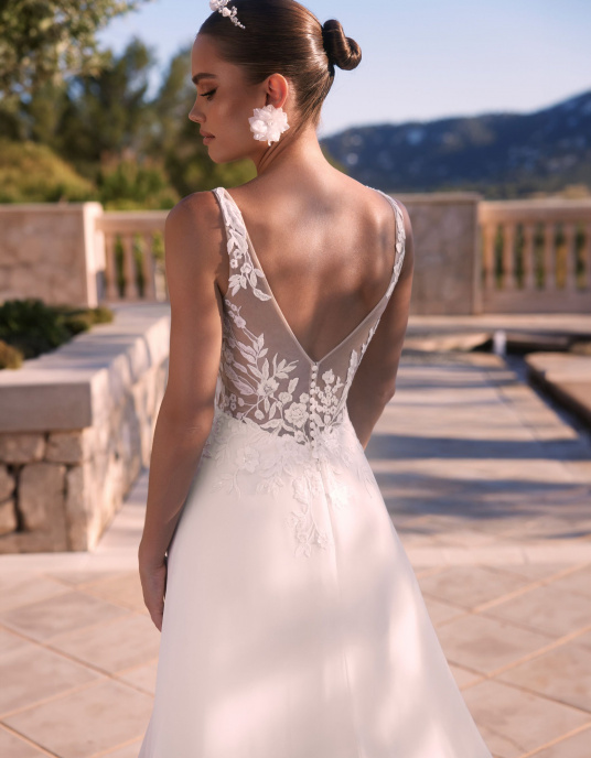 Robes de mariées  Bianco Evento IONE : robe de mariée bohème trapèze en mousseline et dentelle de qualité. Son corsage en dentelle florale, son dos en V et sa longue traîne illusion mettent en valeur la silhouette avec élégance et romantisme. 
