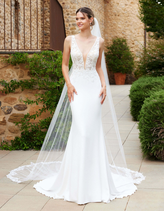 Robes de mariées  Nicole Couture "Saphire" La robe sirène glamour SAPPHIRE affiche une finition cristalline sur l'encolure en V et les manches, parfaite pour les mariées qui veulent être élégantes et confortables lors de leur mariage.  