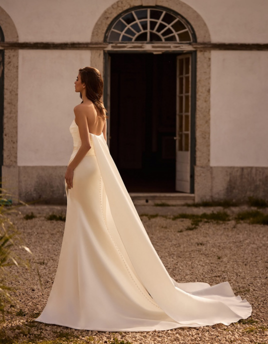 Robes de mariées  ALBERTO PALATCHI BRON est une robe de mariée coupe princesse au style moderne. Elle présente un corsage délicatement drapé et comprend une jupe intérieure amovible en dentelle et perles, créant un effet double look. 