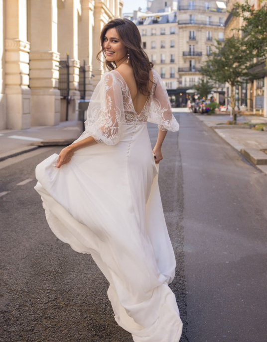 Robes de mariées  Lambert Creation Céleste Allure fluide et légère pour cette robe en mousseline fendue devant, son joli buste à manches bouffantes en tulle brodé fleurs. 