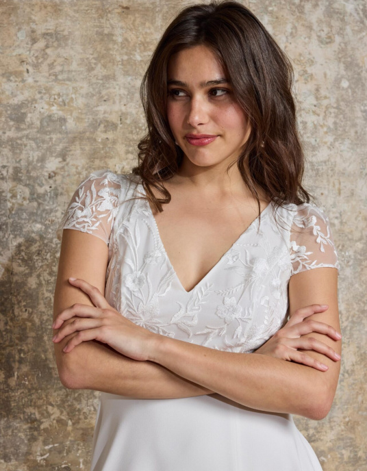 Robes de mariées  Lambert Creation Comète Robe de mariée au style classique et intemporel avec son buste à manches courtes et sa quille en tulle brodé fleurs. 