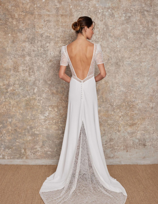 Robes de mariées  Lambert Creation Diane Robe fluide, moderne et sensuelle avec sa jupe fendue, son large décolleté dos et sa quille en tulle brodé en transparence. 
