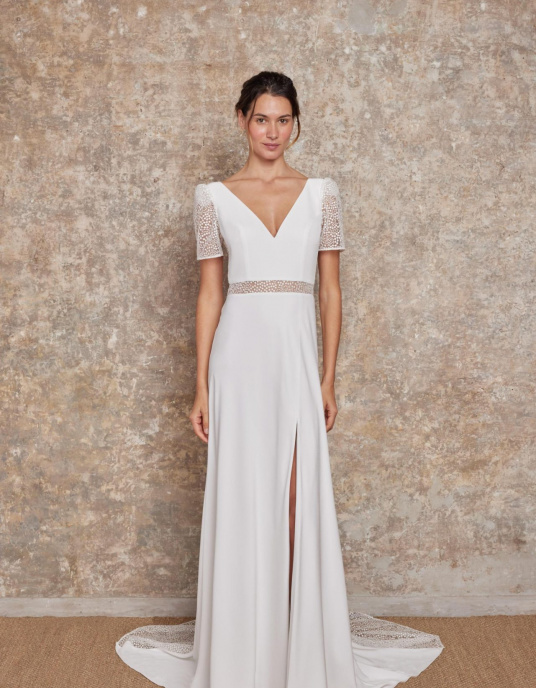 Robes de mariées  Lambert Creation Diane Robe fluide, moderne et sensuelle avec sa jupe fendue, son large décolleté dos et sa quille en tulle brodé en transparence. 