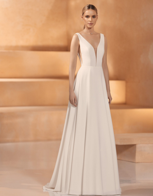Robes de mariées  Nicole Couture "Gobi" apporte une touche romantique avec son décolleté en V devant et dans le dos. Cette robe, sans manches, est un excellent choix pour un mariage. 