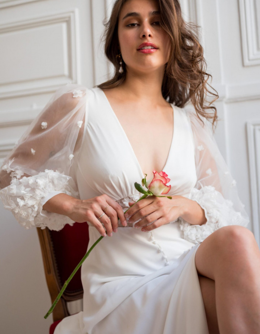 Robes de mariées  Lambert Creation Hélia Robe fendue et boutonnée devant, fluide et originale avec sa ceinture et ses manches longues bouffantes en tulle brodé. 