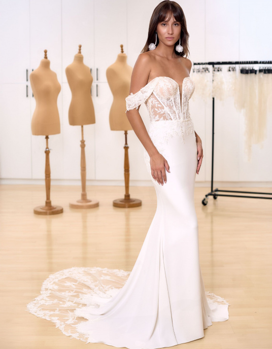 Robes de mariées  Bianco Evento Lali Robe de mariée sirène, sensuelle et parfaitement ajustée, confectionnée en crêpe et dentelle de qualité supérieure. Elle présente une délicate broderie florale en dentelle, un dos droit rehaussé d’un décolleté en cœur, ainsi que des manches tombantes 