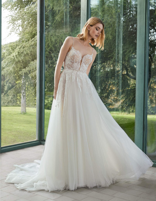 Robes de mariées  Pronovias LLEANE : Une robe en ligne A avec décolleté en cœur et dos en V, inspirée d’une esthétique aérienne. Confectionnée en tulle, dentelle et perles, elle offre une élégance naturelle avec un mouvement romantique. 