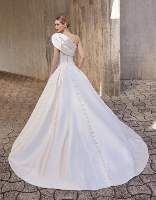 Robes de mariées  Pronovias MAIDEN : Robe de princesse avec un décolleté asymétrique en mikado, proposant une allure audacieuse et élégante avec un mouvement fluide. 