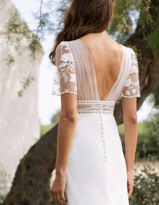 Robes de mariées  Lambert Creation Mustarennes La robe Mustarennes est une véritable pépite fabriquée en France ! Conçue majoritairement en crêpe, elle sublime la silhouette grâce à sa délicate ouverture en dentelle. À l’arrière, un drapé en tulle absolument ravissant apporte la touche fin 