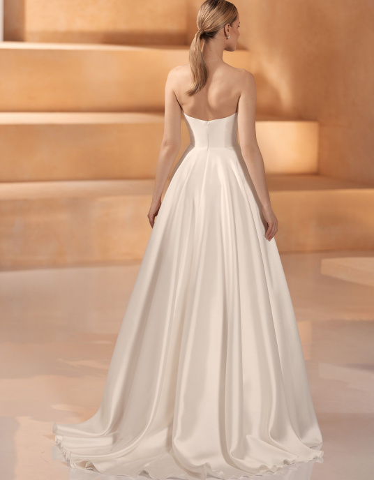 Robes de mariées  Nicole Couture "Olga" Cette robe de mariée sans manches est dotée d'une magnifique traîne cathédrale, d'un décolleté en cœur et d'un dos ouvert. 