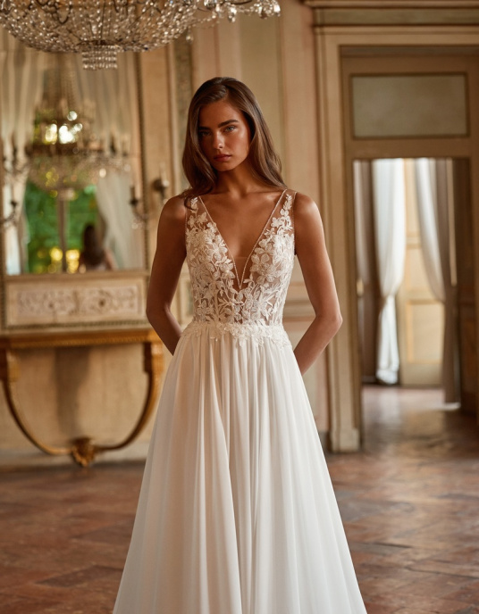 Robes de mariées  ALBERTO PALATCHI RAIATEA Robe de mariée trapèze, corsage en V orné de dentelle, fleurs 3D et perles. Dos entièrement brodé, jupe en mousseline soyeuse. Traîne amovible bicolore incluse. 
